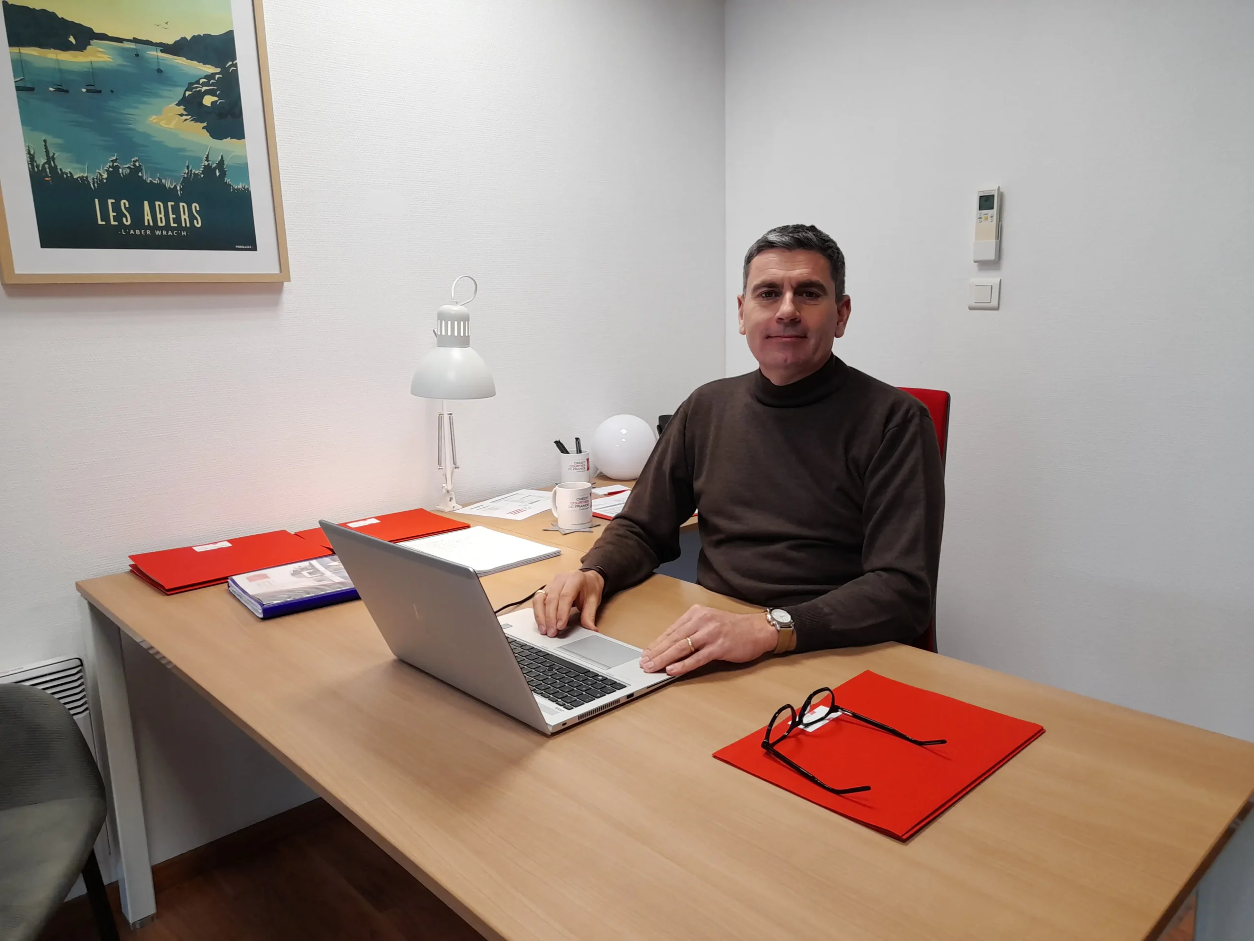 Photographie de Denis Charreteur, dans son bureau à Brest, devant son PC.